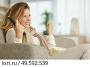 happy woman watching football game on tv. Стоковое фото, агентство Ingram Publishing / Фотобанк Лори