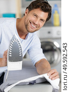 a man is ironing a shirt. Стоковое фото, агентство Ingram Publishing / Фотобанк Лори