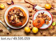 Pumpkin stuffed with granola and dried fruits on old wooden table. Tasty autumn stuffed pumpkin. Стоковое фото, агентство Ingram Publishing / Фотобанк Лори