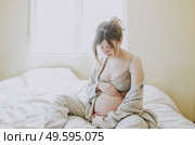 Young pregnant woman alone in home in quarantine                               . Стоковое фото, агентство Ingram Publishing / Фотобанк Лори