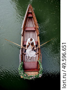 a boat trip for a guy and a girl along the canals and bays of the river overgrown with wild willows. Стоковое фото, агентство Ingram Publishing / Фотобанк Лори