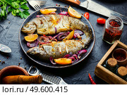 Grilled rainbow trout with lemon and onion on plate.Roasted fish. Two grilled trouts with lemon,fish dish. Стоковое фото, агентство Ingram Publishing / Фотобанк Лори