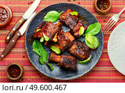 Piece of grilled beef ribs with a dark crust.American food.BBQ beef rib. Glazed barbecue beef ribs with herb. Стоковое фото, агентство Ingram Publishing / Фотобанк Лори