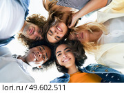 Multi-ethnic group of friends with their heads together in a circle outdoors. Multi-ethnic group of friends with their heads together in a circle. Стоковое фото, агентство Ingram Publishing / Фотобанк Лори