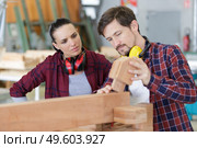 carpenter man and woman working in workshop as a team. Стоковое фото, агентство Ingram Publishing / Фотобанк Лори
