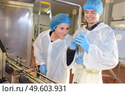 factory workers checking weight of product. Стоковое фото, агентство Ingram Publishing / Фотобанк Лори