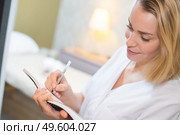 beautician making notes treatment room visible in background. Стоковое фото, агентство Ingram Publishing / Фотобанк Лори