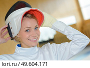 a woman putting the fencing helmet. Стоковое фото, агентство Ingram Publishing / Фотобанк Лори