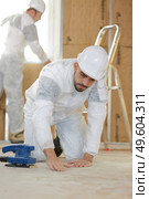 tile installer inspecting the flooring. Стоковое фото, агентство Ingram Publishing / Фотобанк Лори