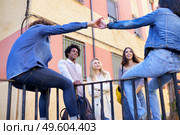 Multi-ethnic group of friends gathered in the street leaning on a railing. Young people having fun together.. Multi-ethnic group of friends gathered in the street leaning on a railing. Стоковое фото, агентство Ingram Publishing / Фотобанк Лори