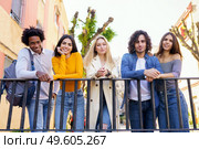 Multi-ethnic group of friends gathered in the street leaning on a railing. Young people having fun together.. Multi-ethnic group of friends gathered in the street leaning on a railing. Стоковое фото, агентство Ingram Publishing / Фотобанк Лори