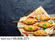 Traditional lula kebab on a wooden skewer. Lamb dish. Eastern cuisine. Lula kebab on a wooden skewer with lavash. Стоковое фото, агентство Ingram Publishing / Фотобанк Лори