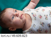 Макросъёмка: крошечная ручка младенца крепко сжимает взрослый палец на размытом фоне жёлтого и синего. Мягкий естественный свет подчёркивает бархатистую кожу и трогательность момента. Образ символизирует доверие, связь поколений и заботу. Стоковое фото, фотограф Владислав Войтов / Фотобанк Лори