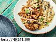 Turkey meat in cheese breading with mushroom sauce.Turkey schnitzel. Turkey steak with fried mushrooms. Стоковое фото, агентство Ingram Publishing / Фотобанк Лори