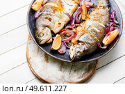 Delicious river trout fried in onion and lemon. Baked rainbow trout, seafood. Whole baked rainbow trout on the plate. Стоковое фото, агентство Ingram Publishing / Фотобанк Лори