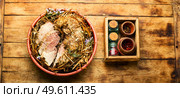 Delicious meat roasted in fresh hay. Baked pork meat in spicy herbs.. Roast pork in hay with herbs,top view. Стоковое фото, агентство Ingram Publishing / Фотобанк Лори