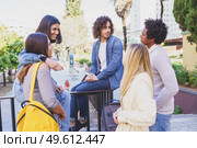 Multi-ethnic group of friends gathered in the street leaning on a railing. Young people having fun together.. Multi-ethnic group of friends gathered in the street leaning on a railing. Стоковое фото, агентство Ingram Publishing / Фотобанк Лори