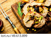 Baked pork with dates, apples and pistachios. Roasted lean pork on cutting board. Meatloaf with dates and apples. Стоковое фото, агентство Ingram Publishing / Фотобанк Лори