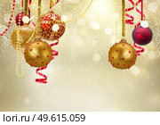 Golden and red christmas balls garland and evergreen fir tree on glowing golden background. Golden christmas balls. Стоковое фото, агентство Ingram Publishing / Фотобанк Лори