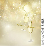 Two festive champagne glasses levitating on golden bokeh background with lights. Two champagne glasses. Стоковое фото, агентство Ingram Publishing / Фотобанк Лори
