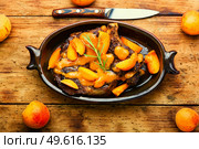 Juicy beef meat in apricot sauce.Veal steak in fruit marinade on old wooden background. Veal steak fried with apricots. Стоковое фото, агентство Ingram Publishing / Фотобанк Лори