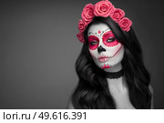 Portrait of a woman with sugar skull makeup over black background. Halloween costume and make-up. Portrait of Calavera Catrina. Стоковое фото, агентство Ingram Publishing / Фотобанк Лори