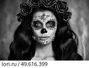 Portrait of a woman with sugar skull makeup over black background. Halloween costume and make-up. Portrait of Calavera Catrina. Стоковое фото, агентство Ingram Publishing / Фотобанк Лори