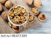 Purified walnuts in a white bowl on a wooden background. Top view. Стоковое фото, агентство Ingram Publishing / Фотобанк Лори