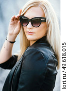 blonde girl in a black trouser suit with blue eyes on the background of a granite quarry from gray rubble. Стоковое фото, агентство Ingram Publishing / Фотобанк Лори