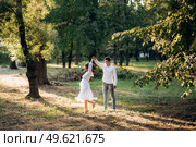 guy and a girl walk along the paths of a forest park between tall trees. Стоковое фото, агентство Ingram Publishing / Фотобанк Лори