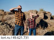Guy and girl in caged shirts and trekking shoes on granite rocks. Стоковое фото, агентство Ingram Publishing / Фотобанк Лори