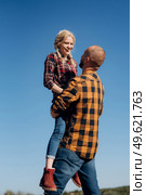 Guy and girl in caged shirts and trekking shoes on granite rocks. Стоковое фото, агентство Ingram Publishing / Фотобанк Лори