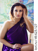 model girl in a blue dress in an art workshop with brushes, a palette and paintings. Стоковое фото, агентство Ingram Publishing / Фотобанк Лори