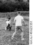 Big dog for a walk with a guy and a girl on the green prairie. Стоковое фото, агентство Ingram Publishing / Фотобанк Лори