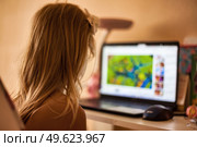 Curious Girl Exploring Colorful Animations on a Laptop in Cozy Indoor Space. Стоковое фото, фотограф Aleksandr Golubev / Фотобанк Лори