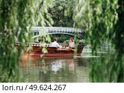 a boat trip for a guy and a girl along the canals and bays of the river overgrown with wild willows. Стоковое фото, агентство Ingram Publishing / Фотобанк Лори
