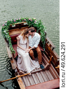 a boat trip for a guy and a girl along the canals and bays of the river overgrown with wild willows. Стоковое фото, агентство Ingram Publishing / Фотобанк Лори