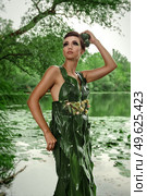 girl in a dress of green palm leaves on a forest lake. Стоковое фото, агентство Ingram Publishing / Фотобанк Лори