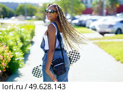 Young black female moving her coloured braids in the wind. Typical African hairstyle.. Black female moving her coloured braids in the wind. Typical African hairstyle. Стоковое фото, агентство Ingram Publishing / Фотобанк Лори