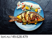 Baked fish carp with fruits, berries and spices. Healthy eating. Tasty crucian fried with kiwi and mango. Стоковое фото, агентство Ingram Publishing / Фотобанк Лори