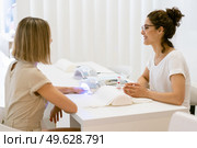 Manicured nails in UV lamp. Small nail art and manicure business. Hands of woman in a wellnes salon. Manicured nails in UV lamp. Small nail art and manicure business. Стоковое фото, агентство Ingram Publishing / Фотобанк Лори