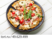 Pizza with salami, cheese, tomato on a pumpkin flatbread. Autumn recipe. Tasty pumpkin-based pizza. Стоковое фото, агентство Ingram Publishing / Фотобанк Лори