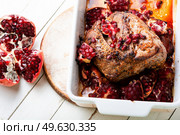 Appetizing piece of pork loin in a fruity marinade. Fried meat with pomegranate in baking dish. Pork roast in pomegranate marinade. Стоковое фото, агентство Ingram Publishing / Фотобанк Лори