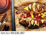 Baked fish carp with fruits and berries in baking dish.. Tasty crucian fried with kiwi and mango. Стоковое фото, агентство Ingram Publishing / Фотобанк Лори