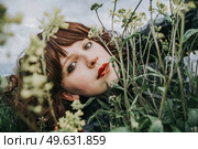 Young beautiful woman resting in a field of flowers. Стоковое фото, агентство Ingram Publishing / Фотобанк Лори