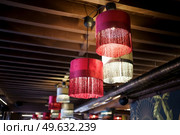 Chandeliers illuminating spacious contemporary pub with old wooden beamed ceiling.. Interior of modern restaurant with chandeliers hanging from a wooden beam ceiling. Стоковое фото, агентство Ingram Publishing / Фотобанк Лори