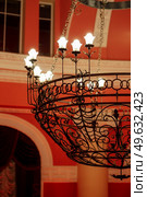 antique ceiling chandelier with lamps in red light on vaulted ceiling. Стоковое фото, агентство Ingram Publishing / Фотобанк Лори