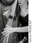 harpist playing an old harp in the garden. Редакционное фото, агентство Ingram Publishing / Фотобанк Лори