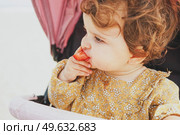 Little baby girl eating a strawberry. Стоковое фото, агентство Ingram Publishing / Фотобанк Лори