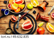 Smoking kalian or shisha with tobacco from citrus fruits. Traditional oriental shisha for relaxation. Hookah with citrus tobacco. Стоковое фото, агентство Ingram Publishing / Фотобанк Лори